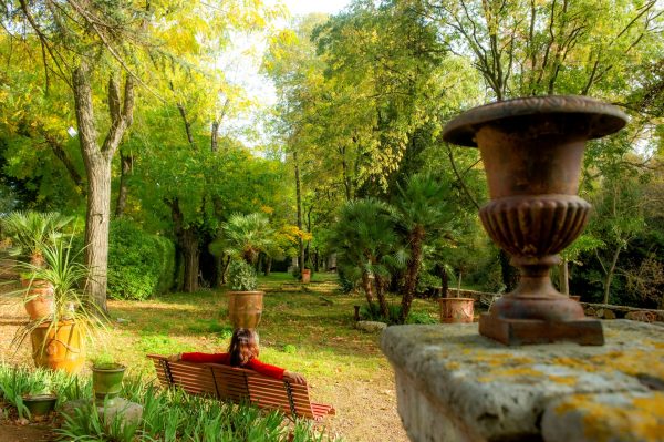 Aniane, jardin du Domaine de Rieussec, jeunior, de dos assise sur un banc