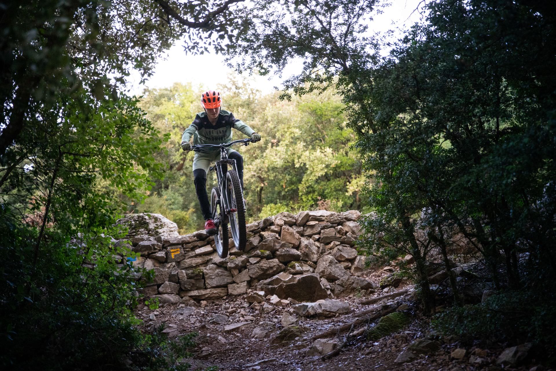 vtt enduro - une vététiste fait un saut dans le Caroux