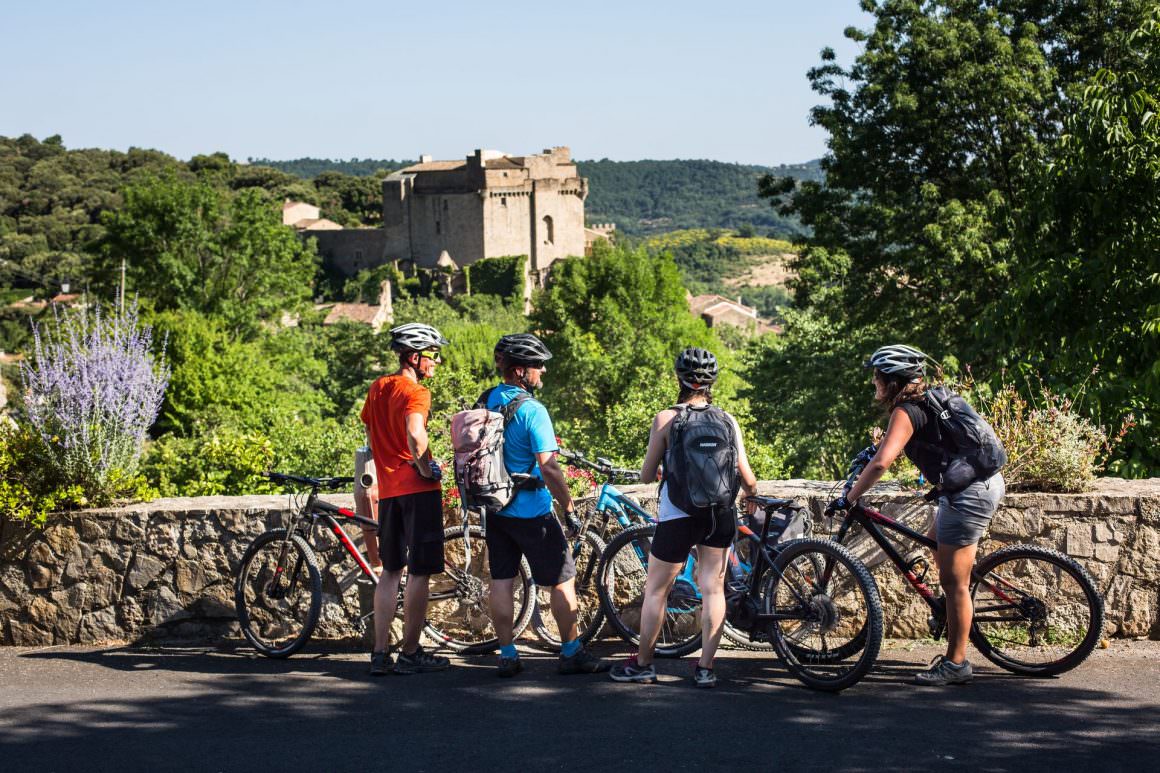 un groupe de vététistes admire le château de Dio