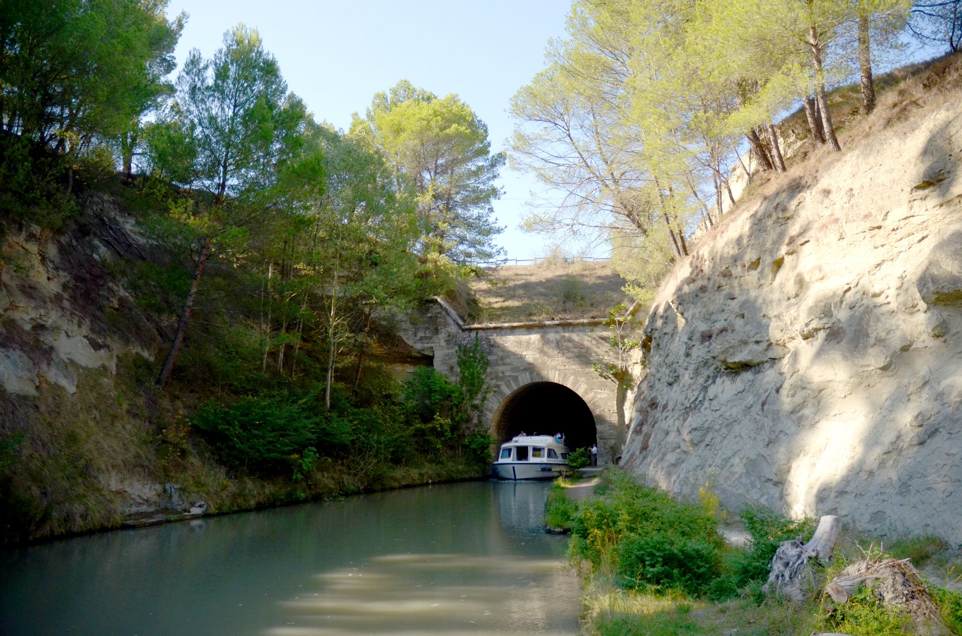 Bateau sur le Canal du Midi qui sort du tunnel du Malpas