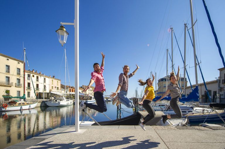 Un bande d'amis de jeunes, en train de faire les fous et de sauter, sur le quai, au bord du Canal à Marseillan