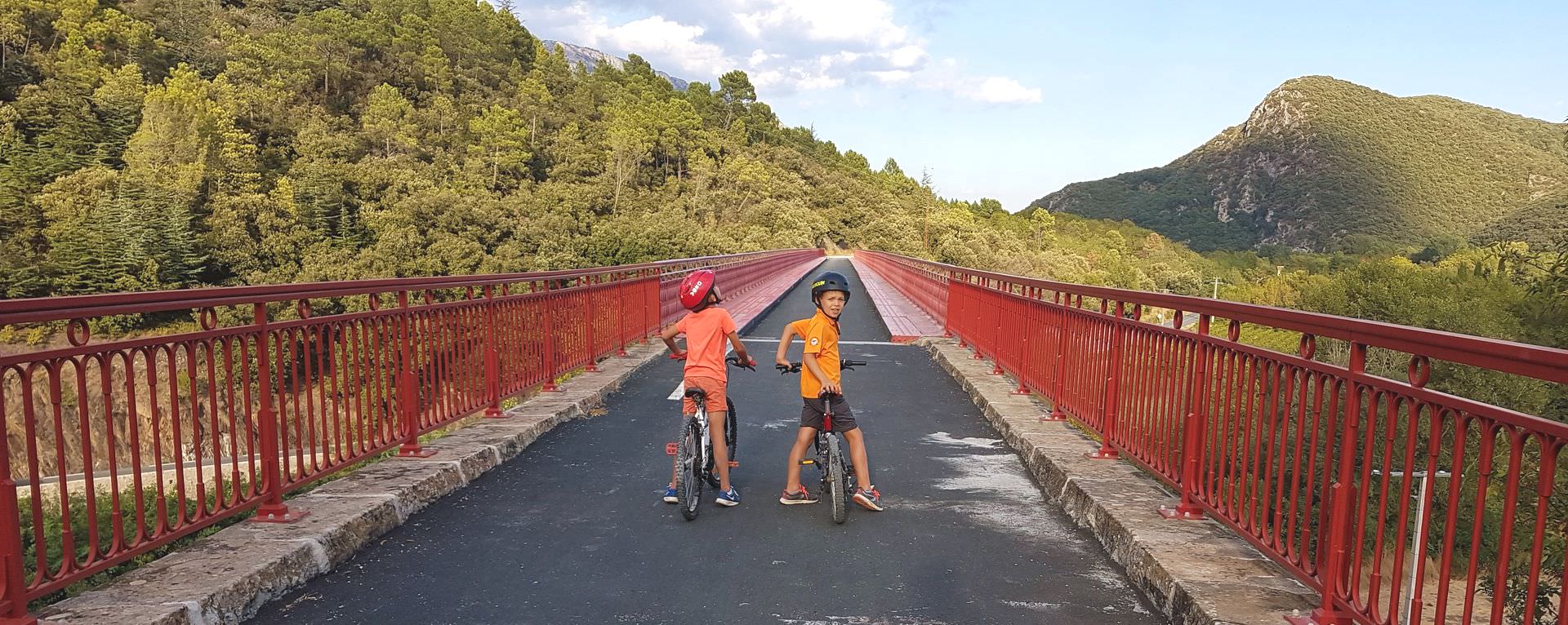 Enfants à vélo sur le pont type Eiffel d'Olargues