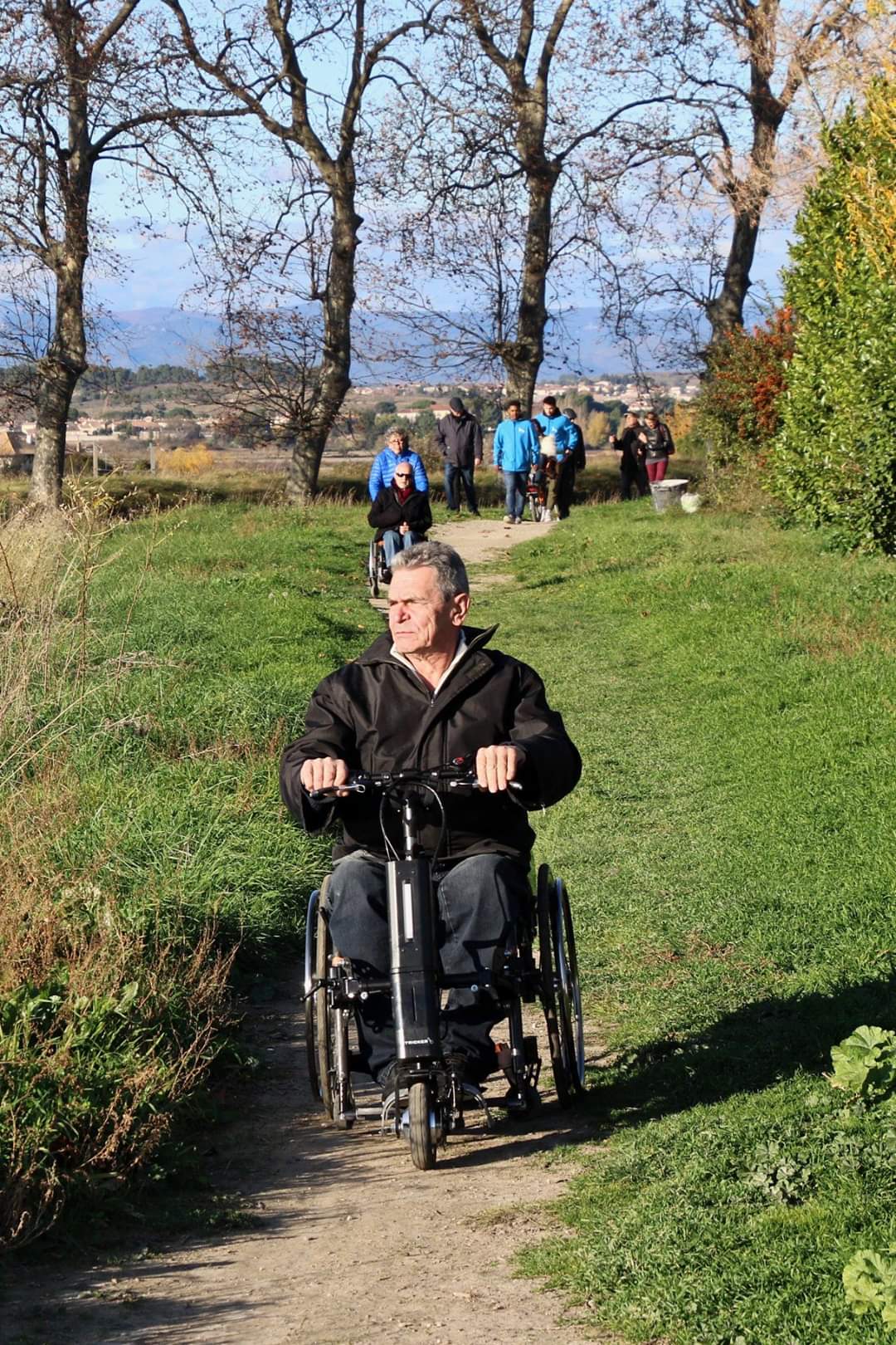 Homme sur un fauteuil avec une 3ème roue électrique