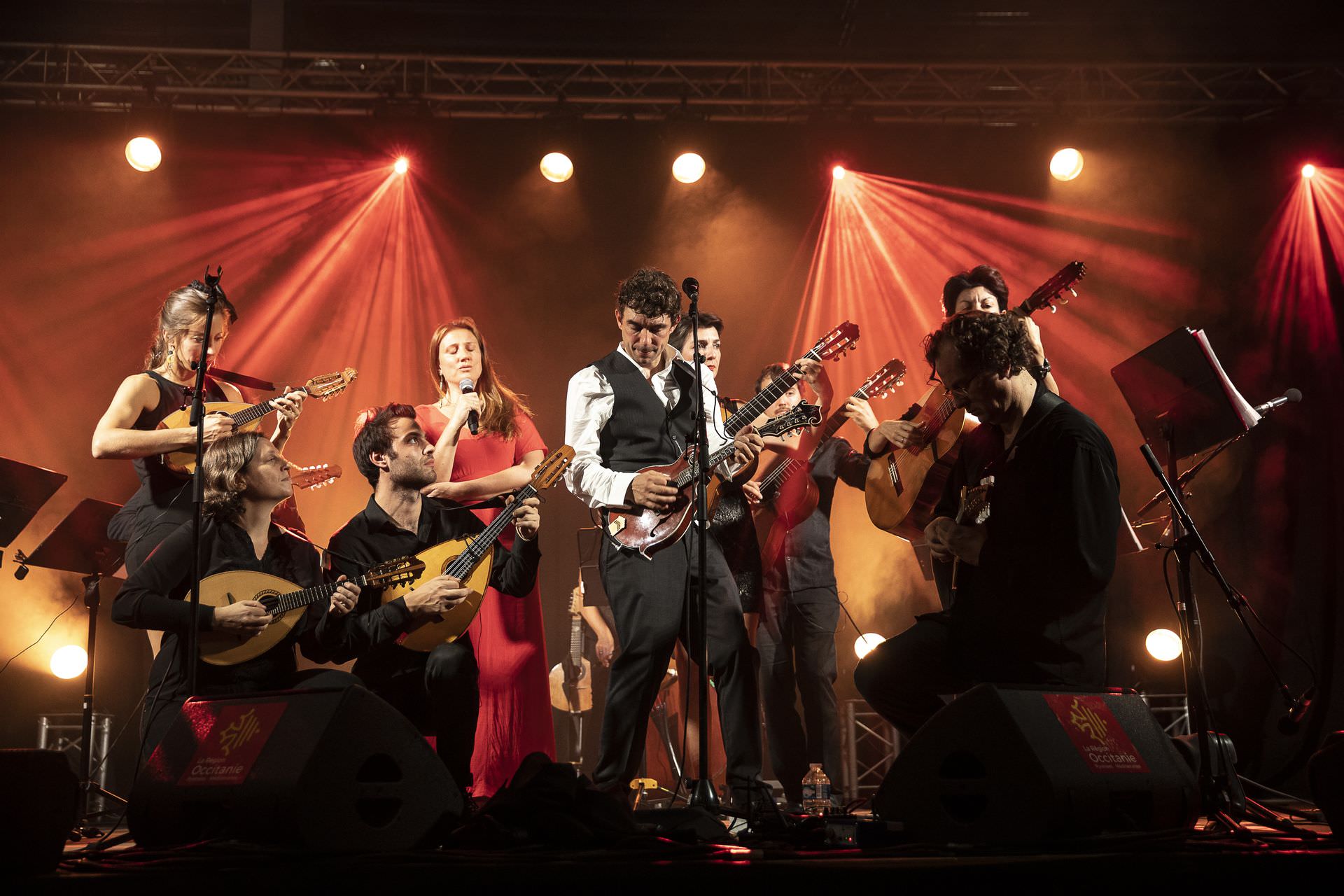 Feloche et musiciens en train de jouer de la guitare et autres instruments à cordes sur la scène de l'Opéra à Montpellier dans le cadre des Internationales de la Guitare Sud de France