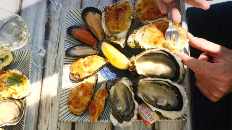 Moules et huitres gratinées et crues dans une assiette prêtes à être dégustées