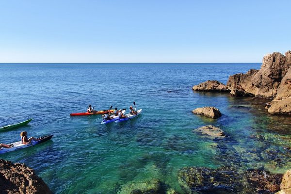 Groupe de personnes en Kayak de mer au pied des falaises de Sète