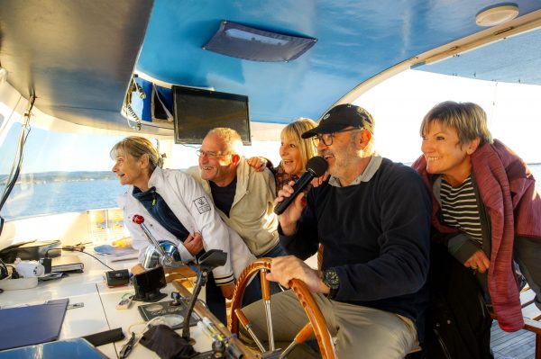 Un groupe d'amis de jeuniors, sur bateau promenade sur l'étang de Thau, en train de rigoler en écoutant le capitaine au micro qui racontent la visite...