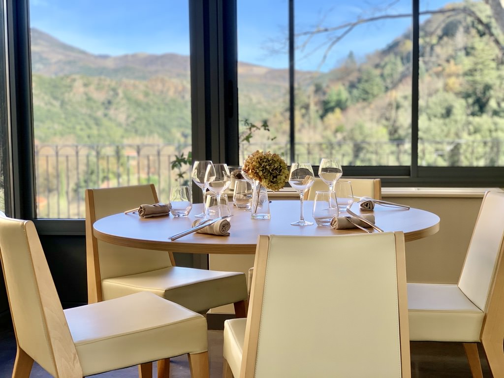 Table du restaurant L'Ortensia avec vue panoramique sur la nature environnante