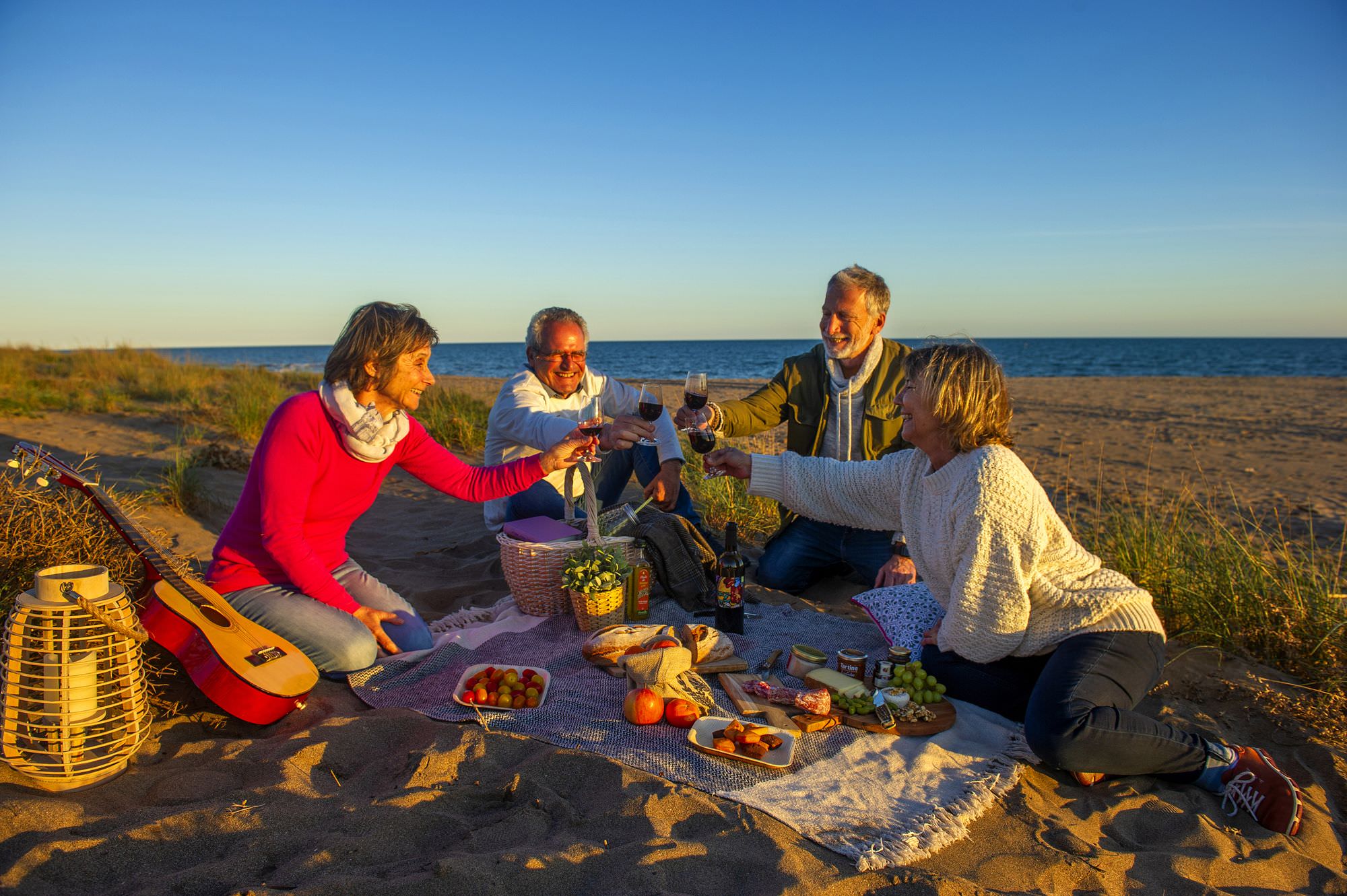 Groupe d'amis couple jeuniors en train de pique niquer sur la Plage de Portiragnes