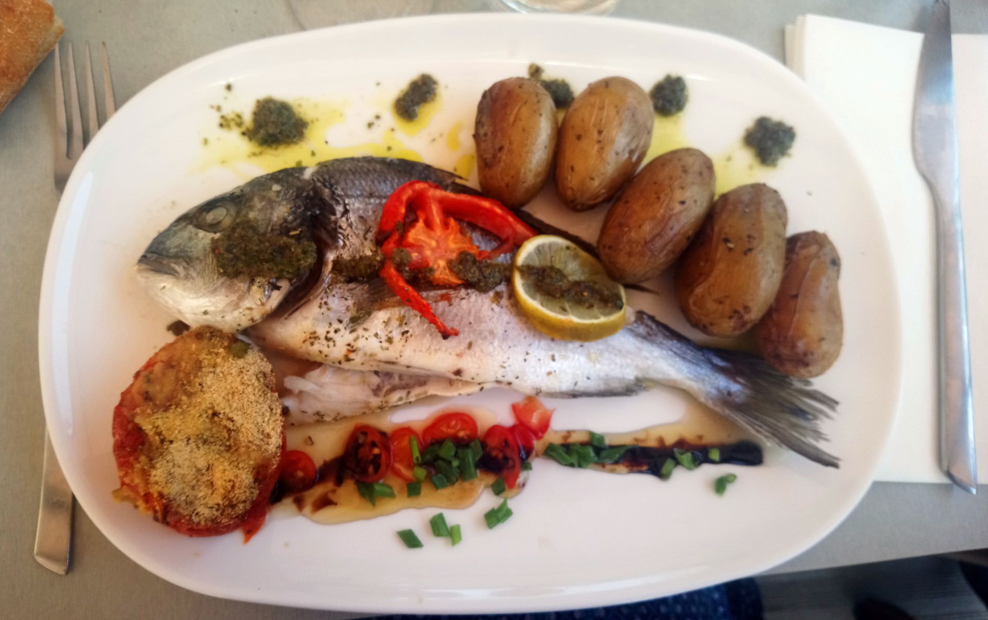 Dorade Royale cuisinée © S. Lucchese Plat avec une dorade royale accompagnée de pommes de terre, tomate et citron