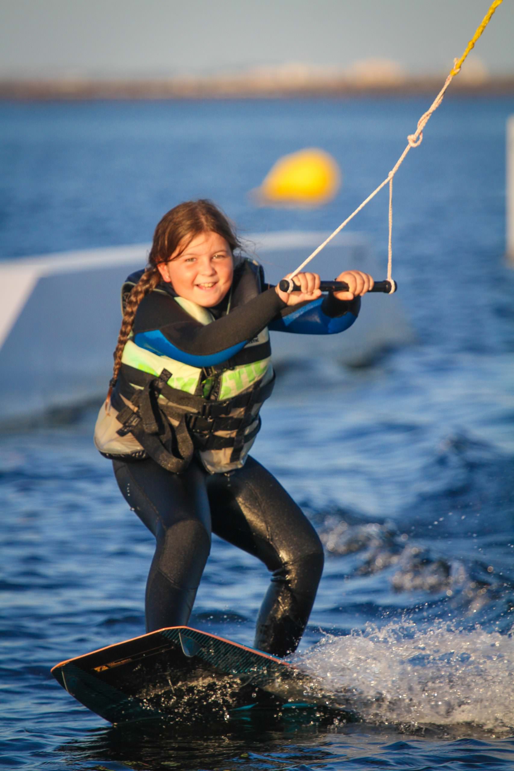 Petite fille en wakeboard sur un Téléski nautique sur l'étang de Thau avec Kithau