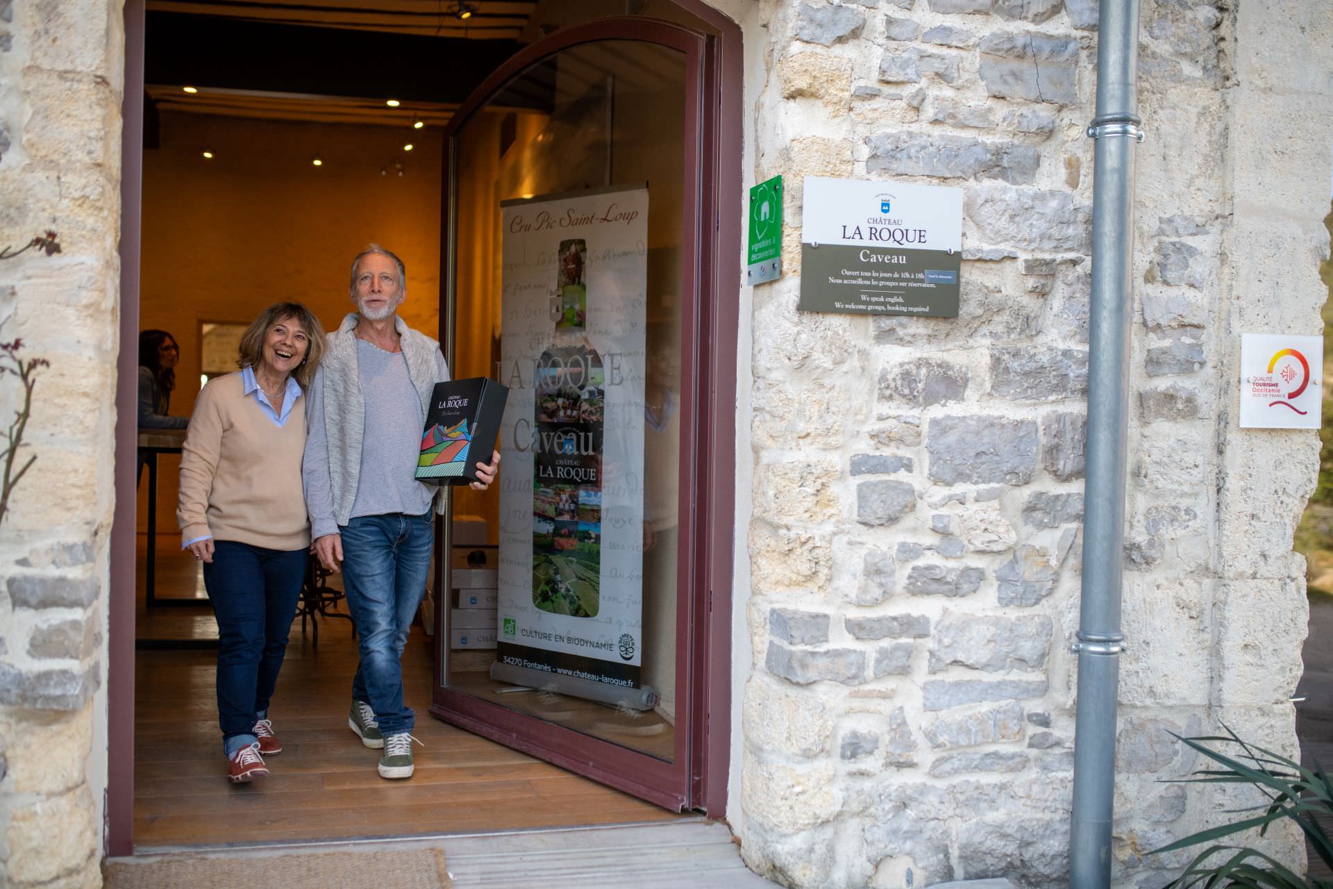 Couple de cinquantenaires heureux sortant d'un domaine viticole carton sous le bras