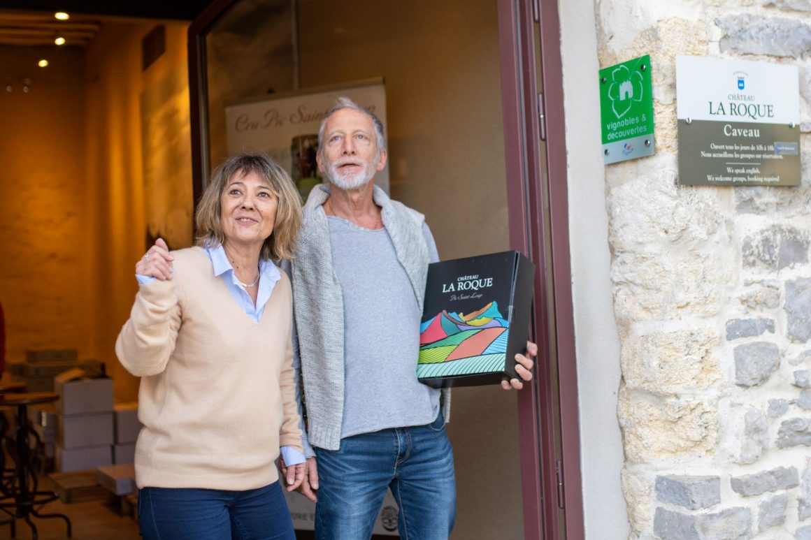 Couple de cinquantenaires heureux sortant d'un domaine viticole carton sous le bras