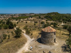 Vue des hauteurs avec des moulins d'Ensérune vers le village d'Ensérune