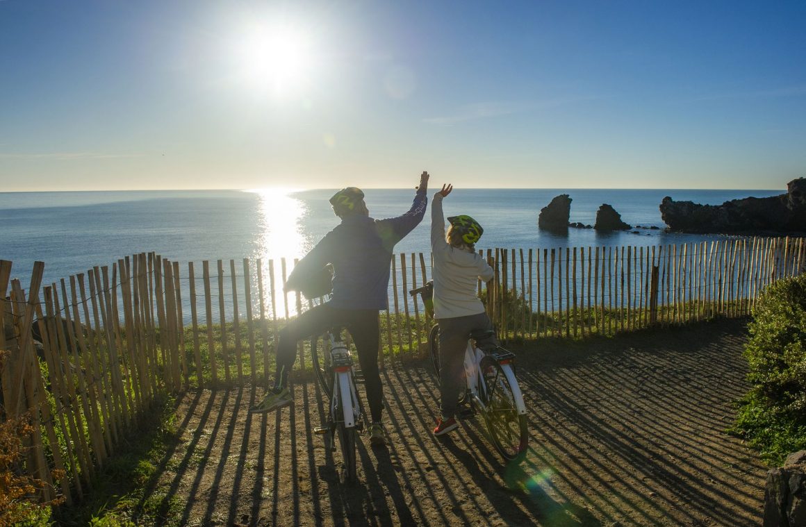 Un couple de quincas se balade à vélo sur les falaises de la Plage de la Conque au Cap d'Agde