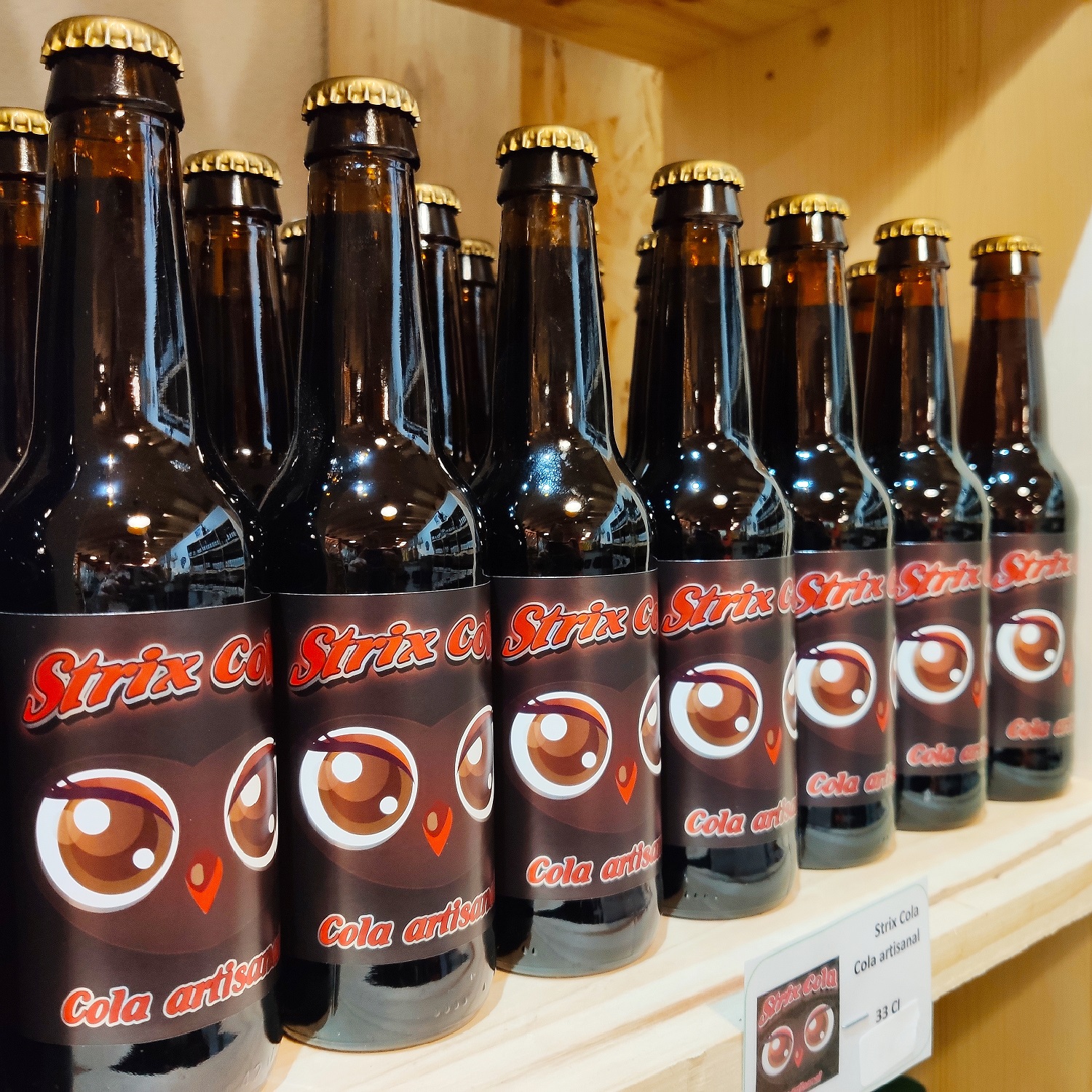 Bouteilles de strix cola sur étagère de la Brasserie des Aucels à Bédarieux