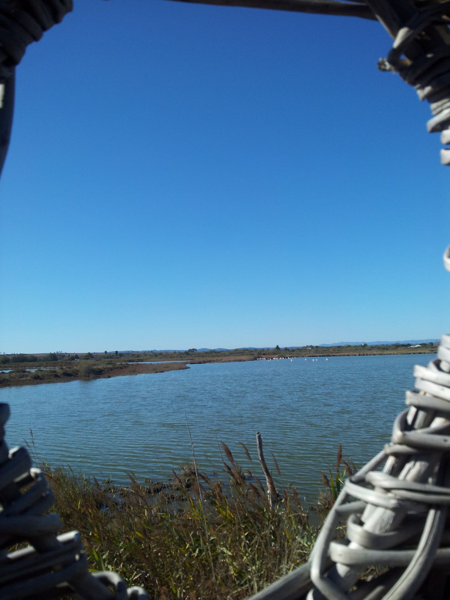 Vue sur l'étang du Méjean au travers la fenêtre d'un ouvrage vannier