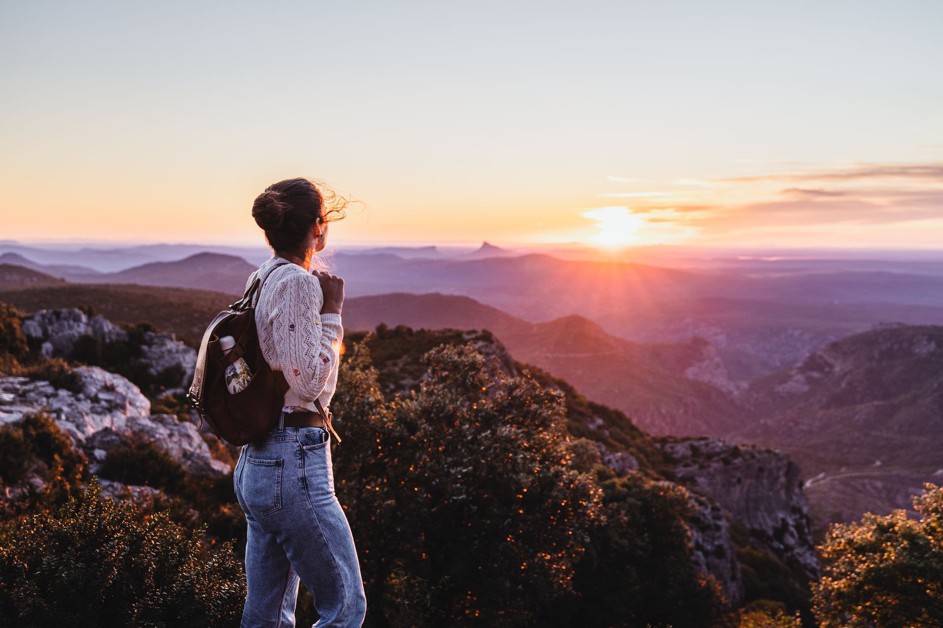 Jeune femme qui admire un lever de soleil au Mont Saint-Baudille