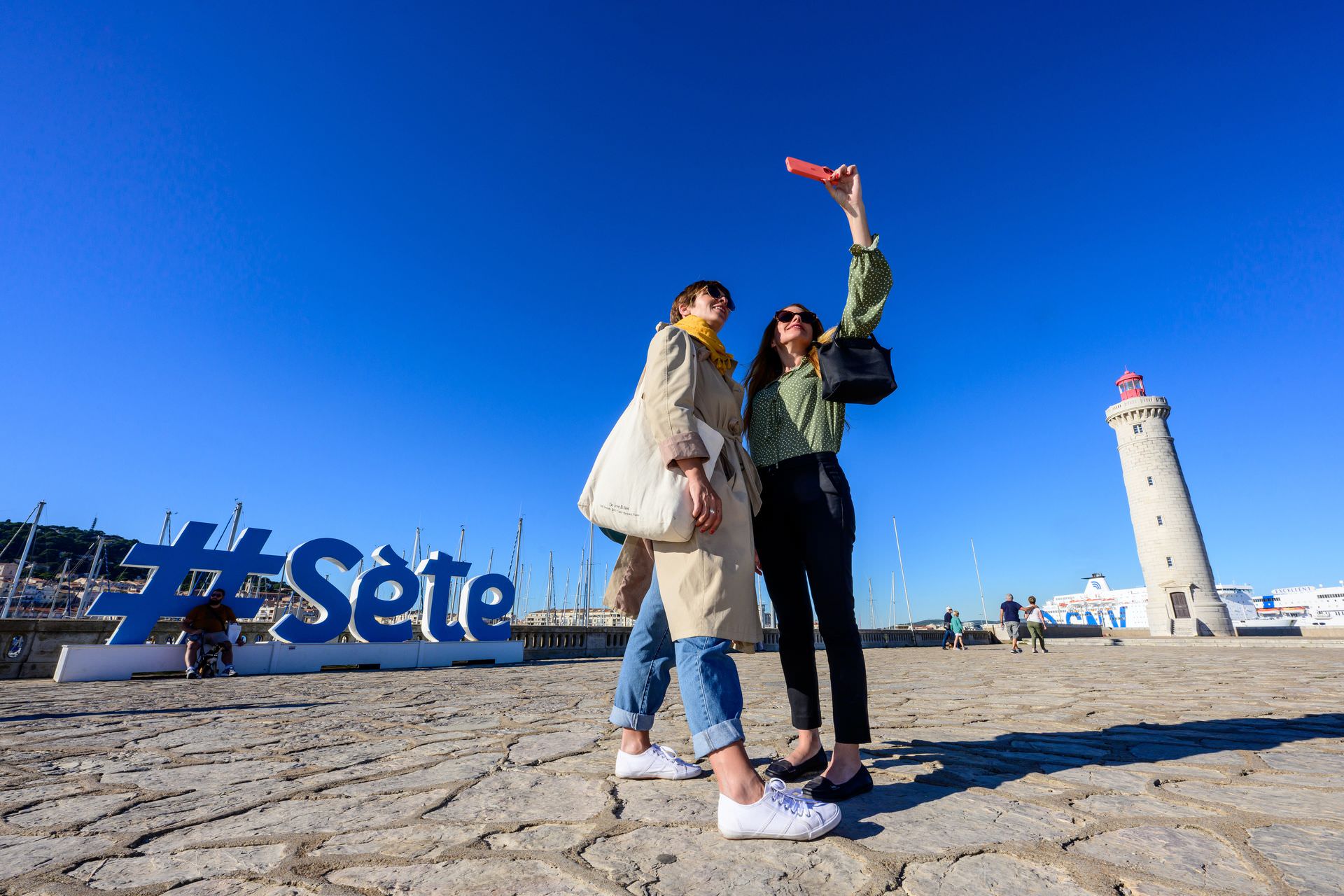 Copines qui se prennent en selfie devant le phare de Sète