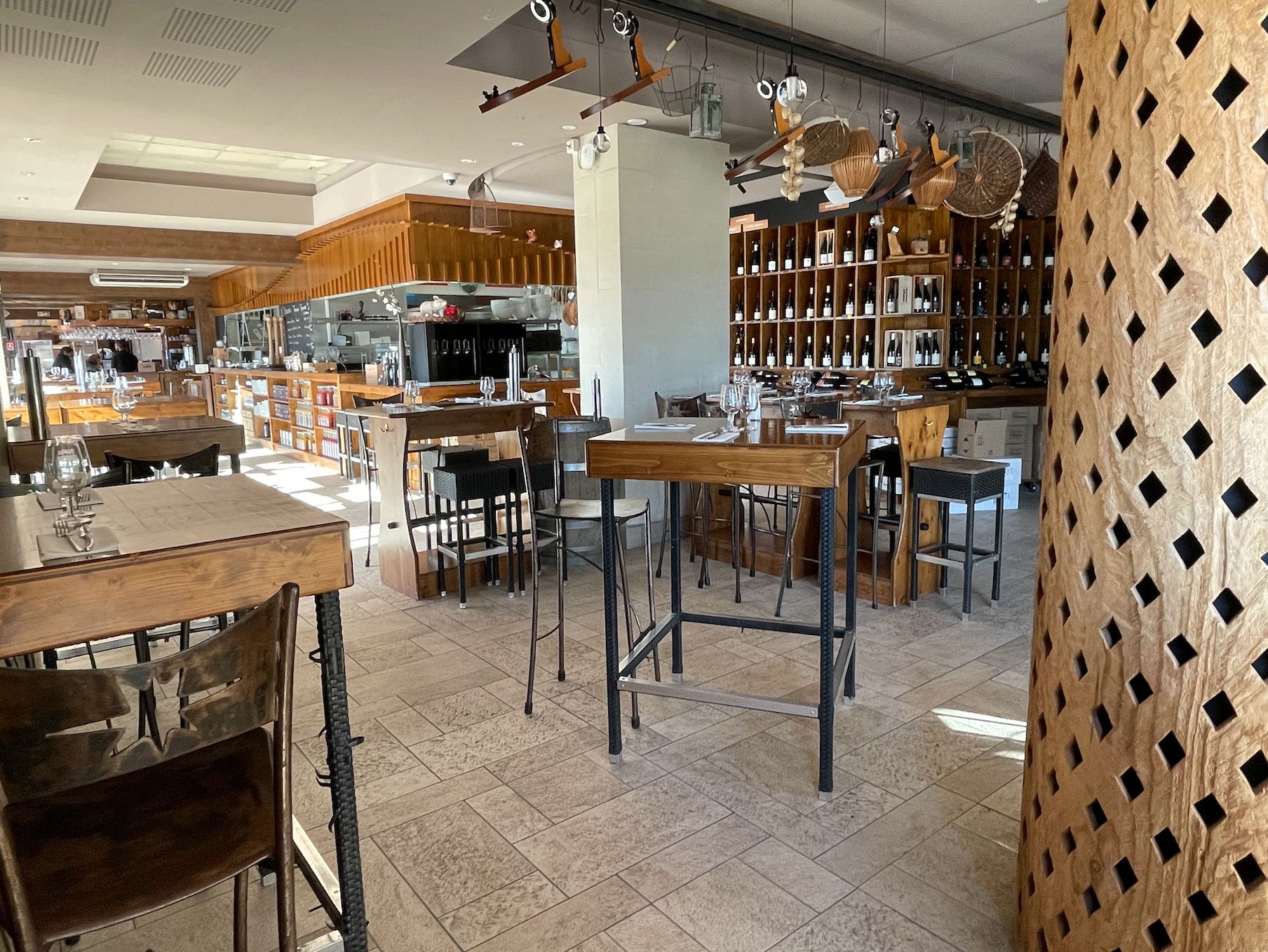 Tables et tabourets hauts à l'intérieur du bar restaurant Le Trinque Fougasse