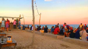 Des personnes regardent le coucher de soleil sur la mer