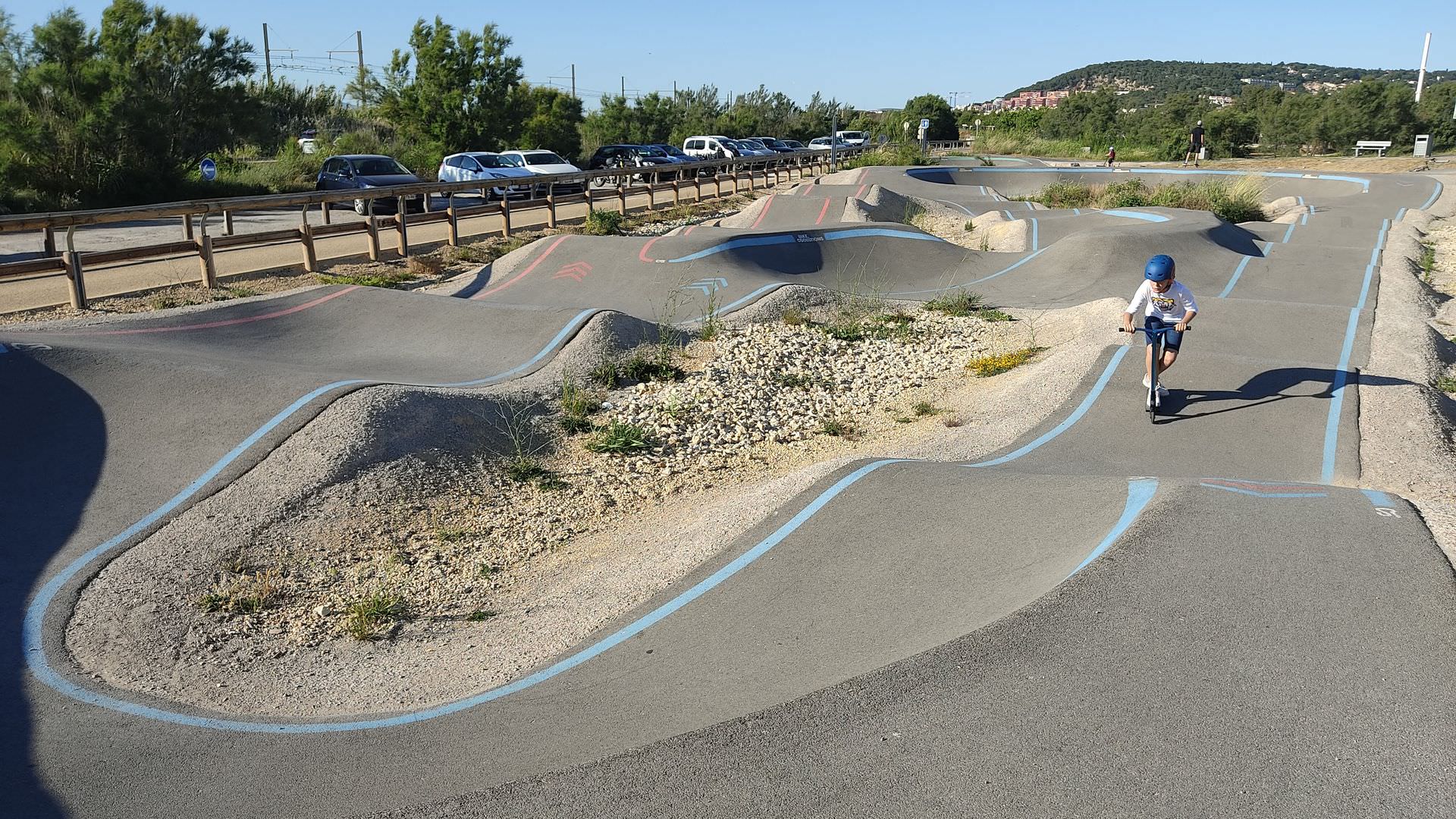 En trottinette sur la pumptrack de Sète près de la voie verte du lido et de la mer Méditerranée