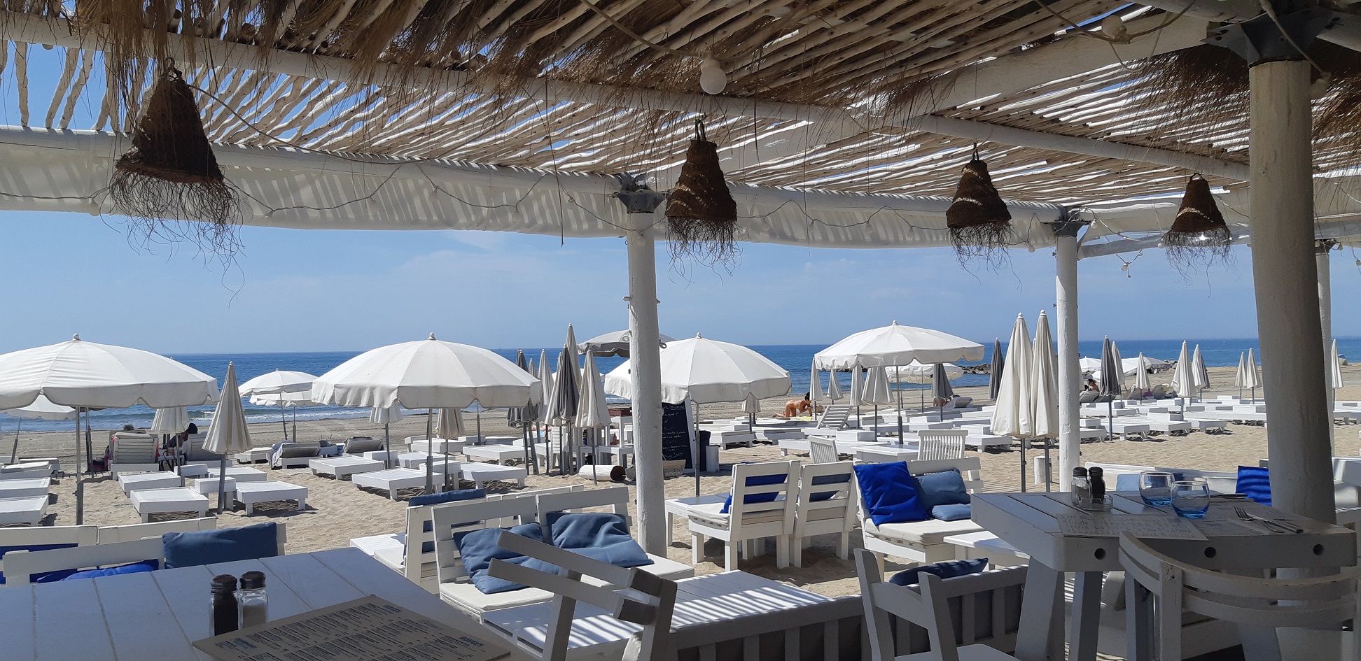 Paillotte sur la plage de Sète avec des tables et des bains de bains blancs