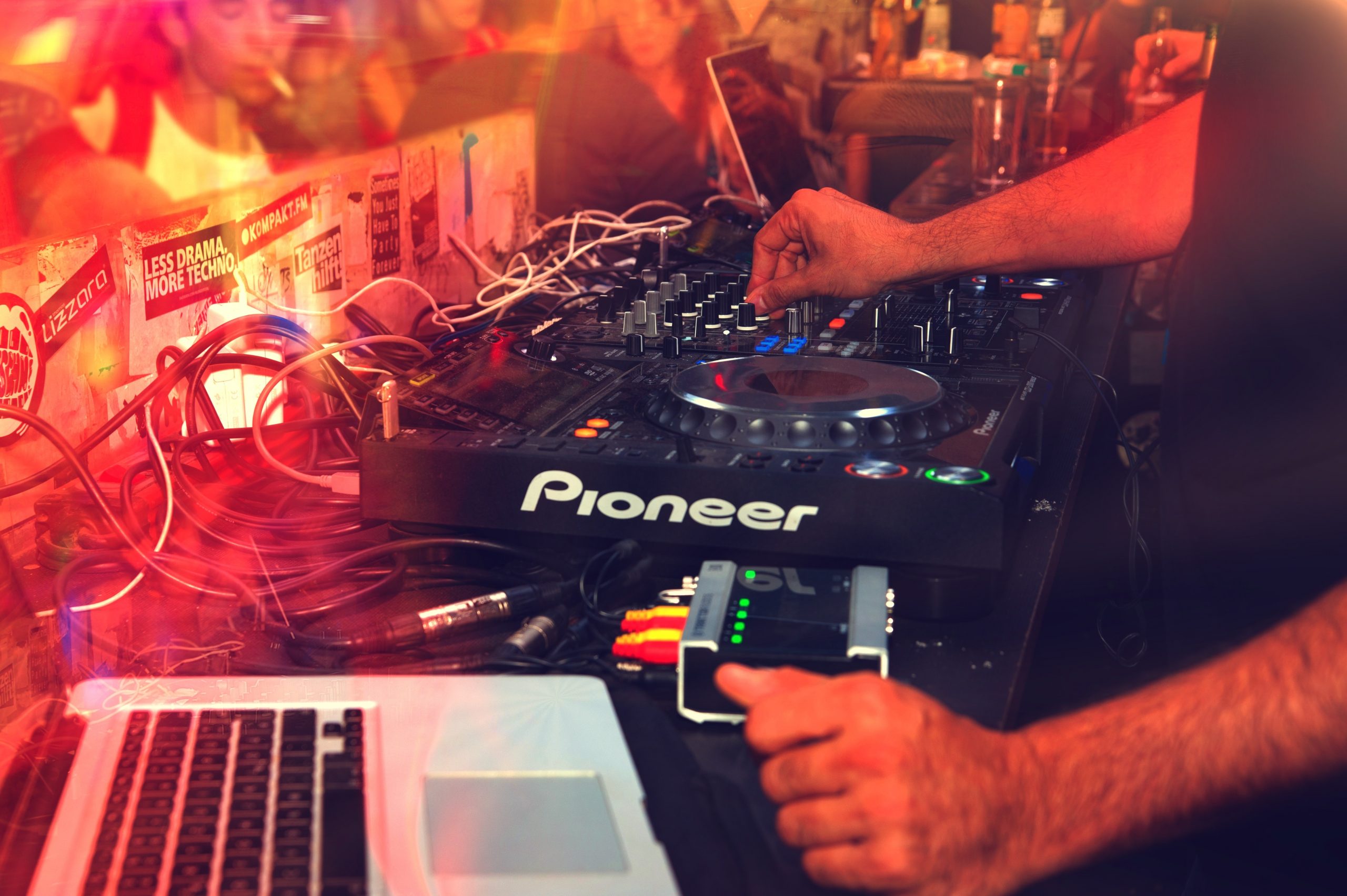 Un DJ aux platines en train de mixer devant un public de jeunes gens