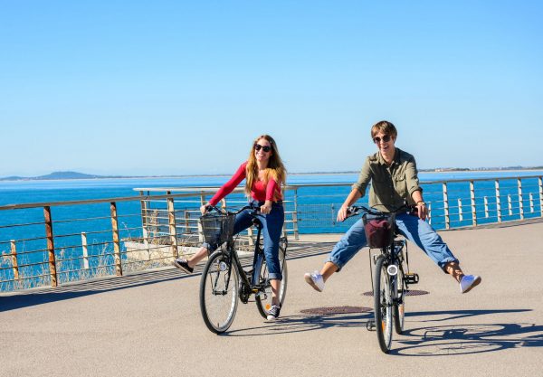 Deux copines en vélo sur la corniche de Sète le long de la mer Méditerranée