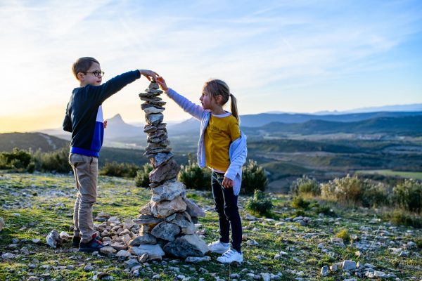 Deux enfants montent un cairn au Puech des Mourgues