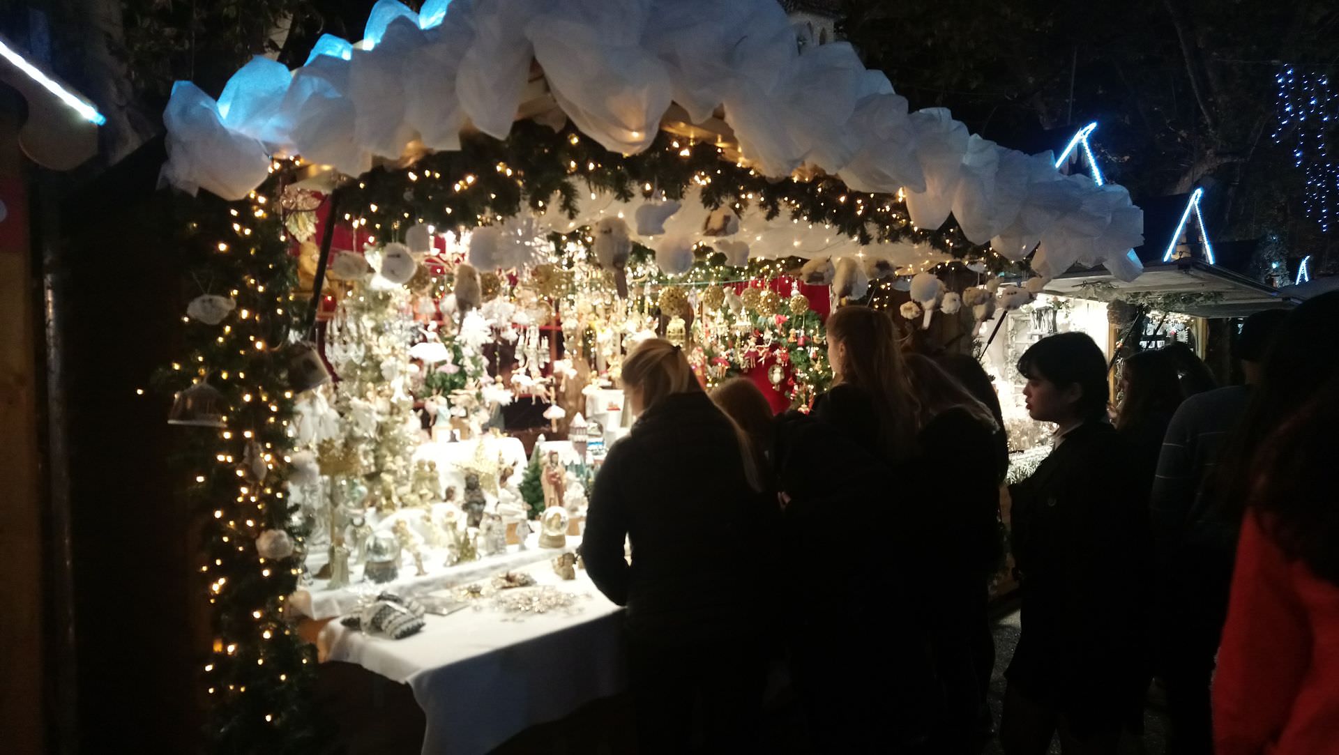 Des passants devant un chalet de Noël durant les Hivernales de Montpellier