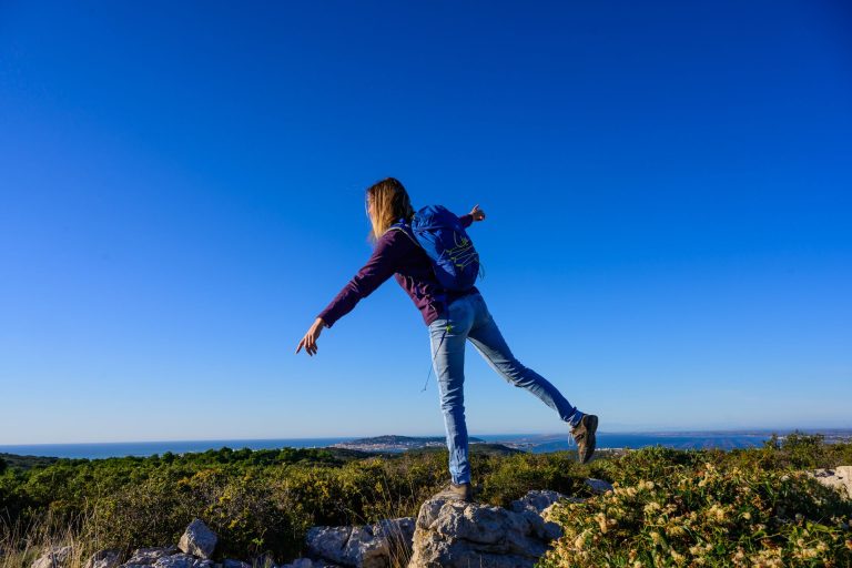 Une jeune femme sur les hauteurs du massif de la Gardiole qui admire le point de vue sur le mont Saint Clair, Sète et la Méditerranée