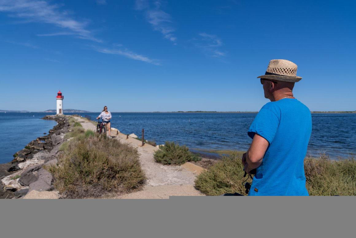Couple de jeuniors en vélo au Phare des Onglous à Marseillan Archipel de Thau