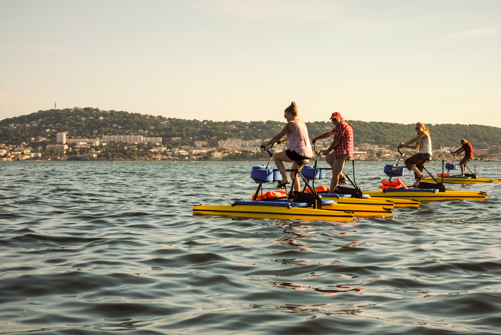 Personnes qui font du vélo sur le bassin de Thau face à Sète