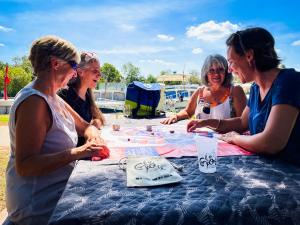 Des amies se détendent en jouant au bord du Canal du Rhône à Sète avec le Comporte, sac à dos vigneron, en Vignobles de Vidourle Camargue