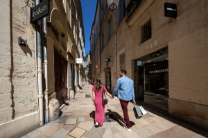 Jeune couple en séance shopping qui se balade main dans la main dans les ruelles médiévales de l'Ecusson à Montpellier