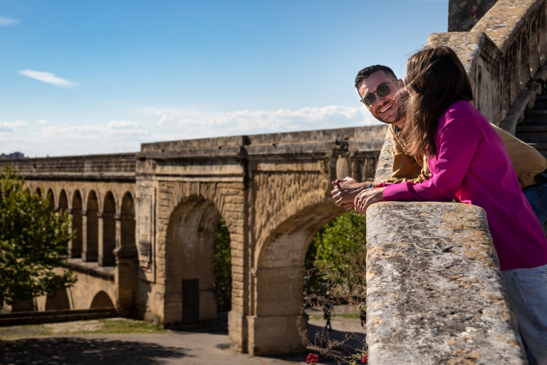 Jeune couple en promenade au Peyrou à Montpellier, avec les Arceaux en second plan