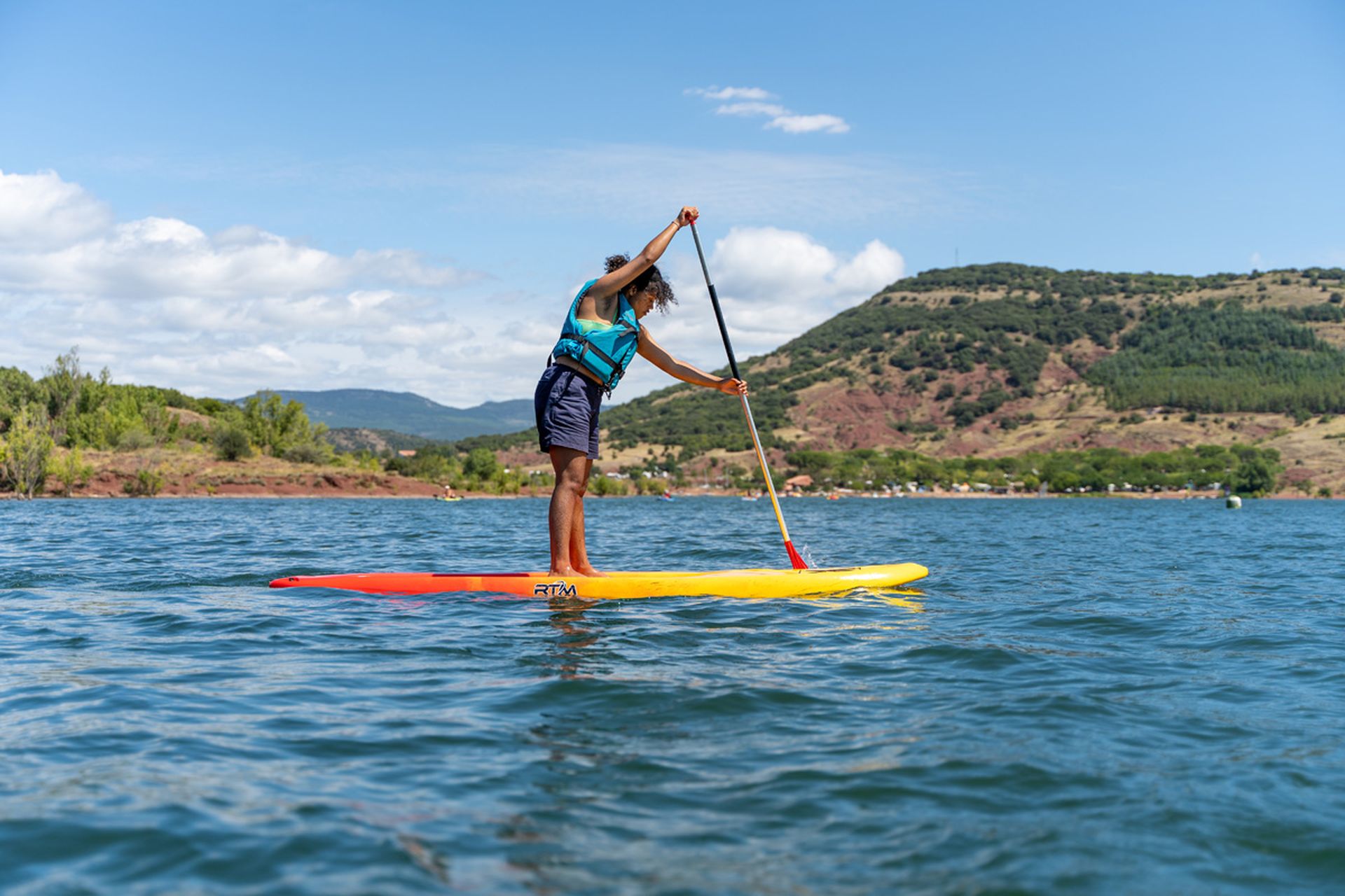 Jeune fille qui fait du paddle sur le lac du Salagou