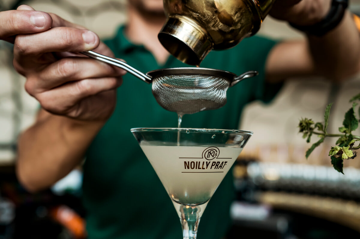 Personne qui rempli un verre de cocktail à La maison Noilly