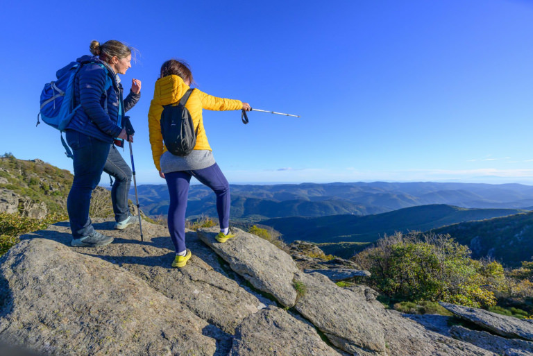 Deux amies randonnent et admirent le panorama sur la vallée depuis le lac de Vésoles dans le Haut-Languedoc