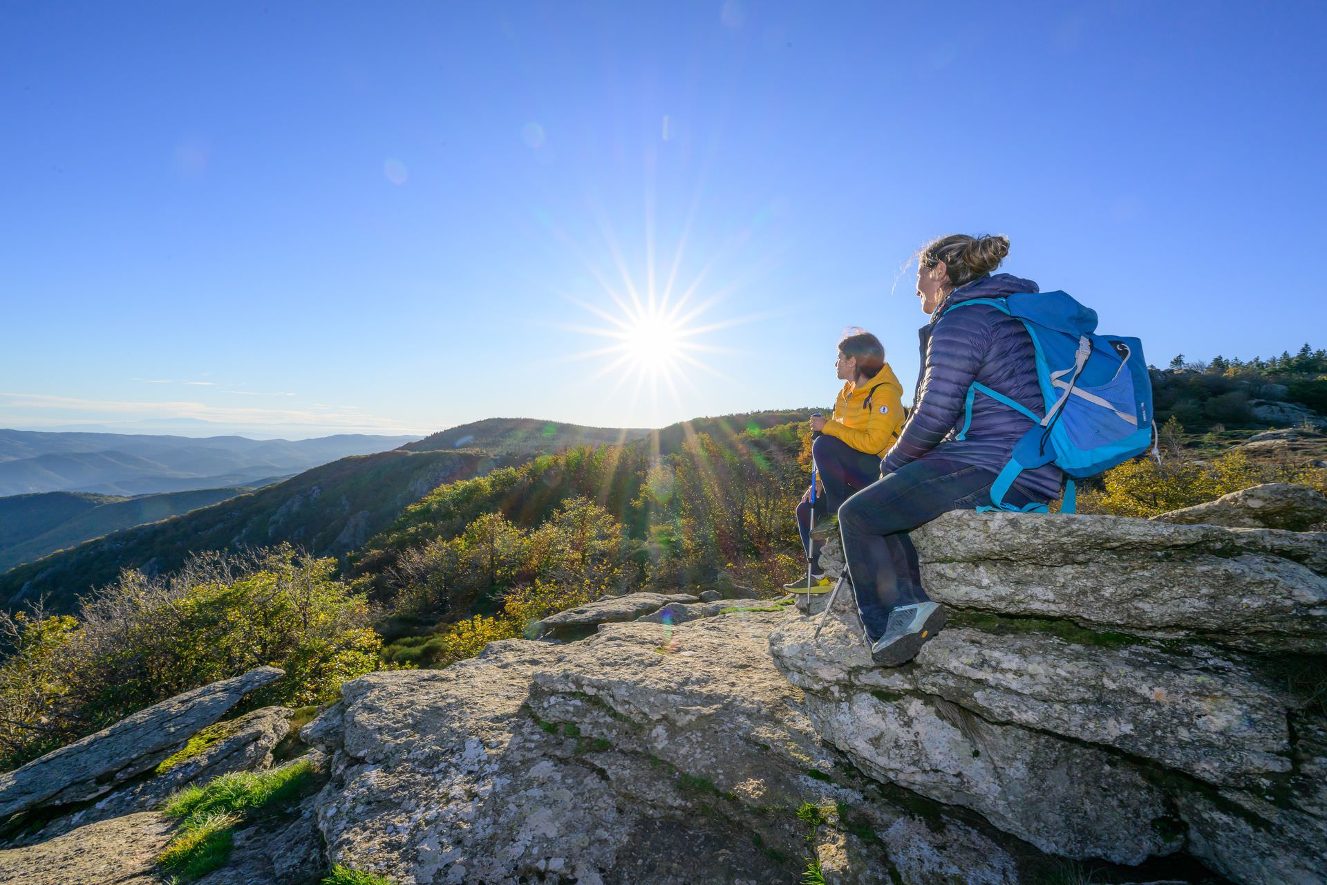 Deux amies randonnent et admirent le panorama sur la vallée depuis le lac de Vésoles dans le Haut-Languedoc