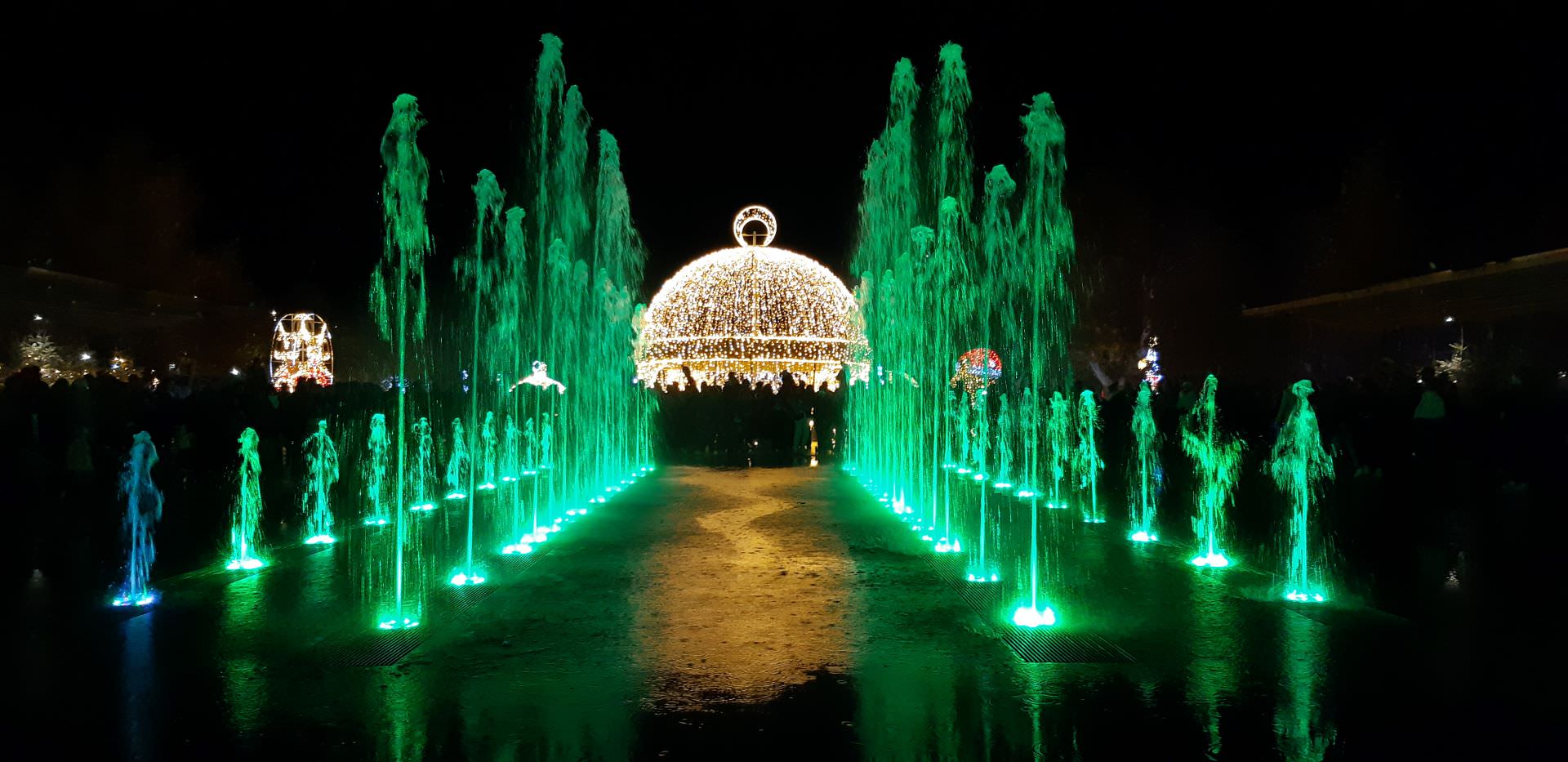 Les fontaines musicales avec des jets d'eau verts dansent sur la musique avec en arrière plan un dôme dorée