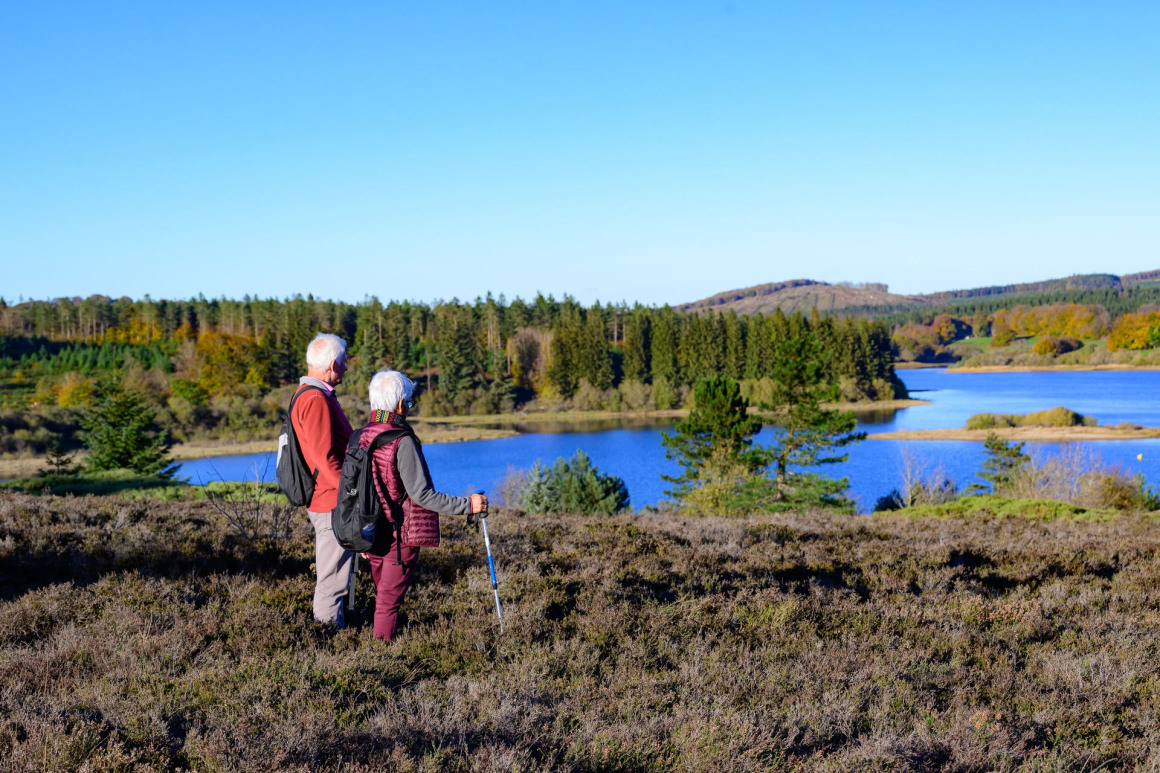 Un couple de randonneurs admire la vue sur le lac de Vesoles dans le Haut-Languedoc