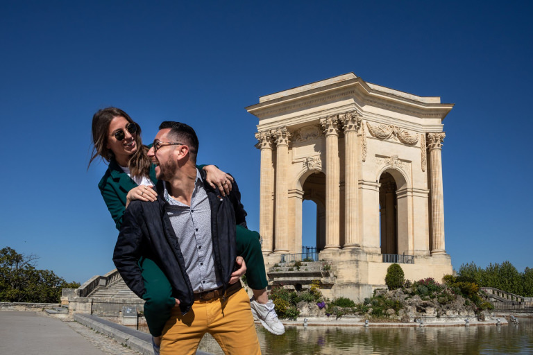 jeune couple qui se balade devant le Château d'eau du Peyrou à Montpellie