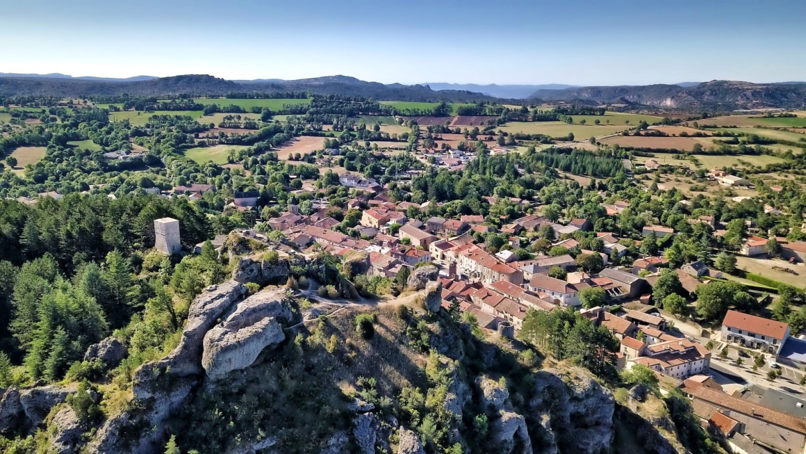 Vue aérienne sur le village-étape du Caylar-en-Larzac et sur le Roc Castel qui veille sur le village