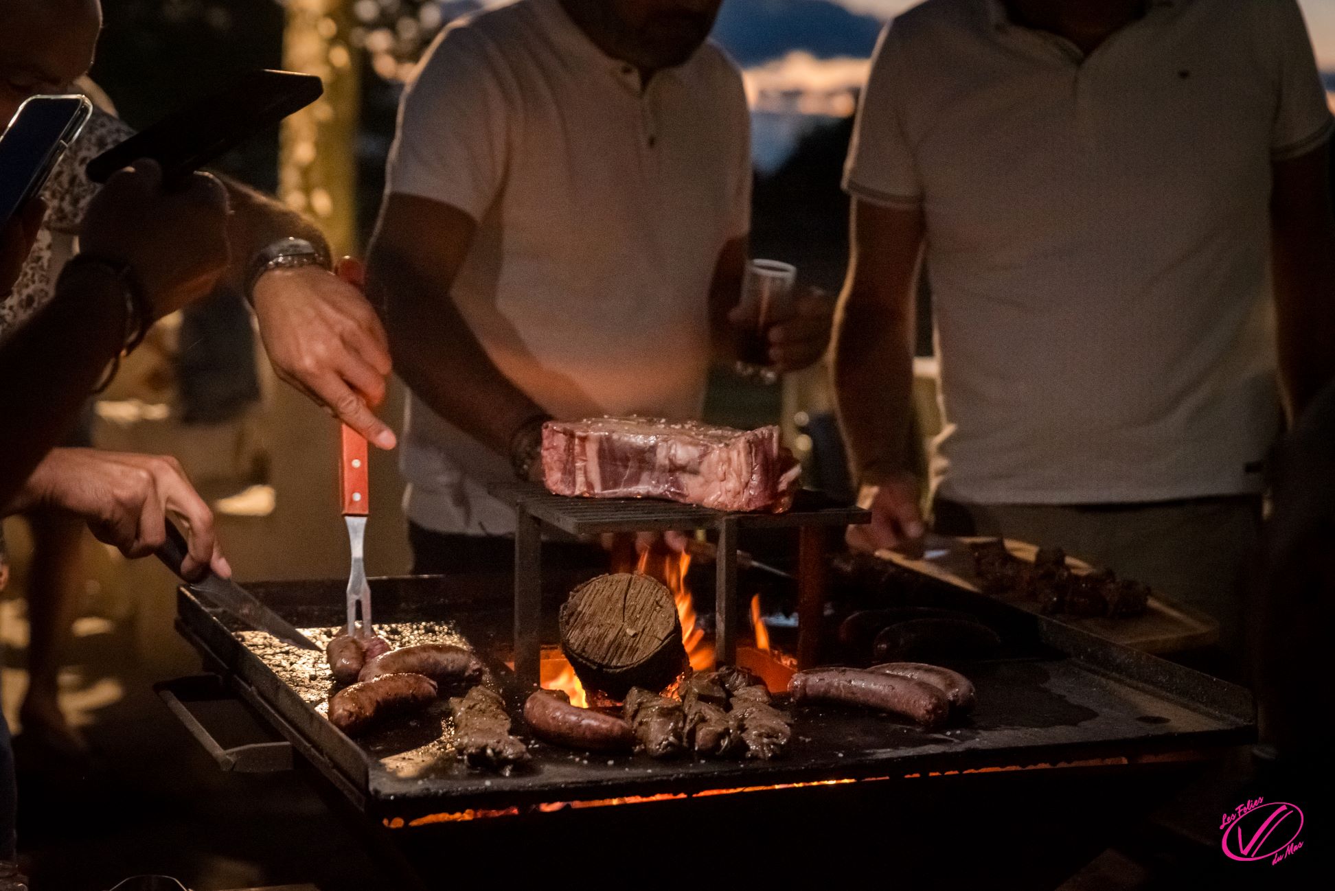 2 hommes la nuit font cuire au barbecue saucisses et viande