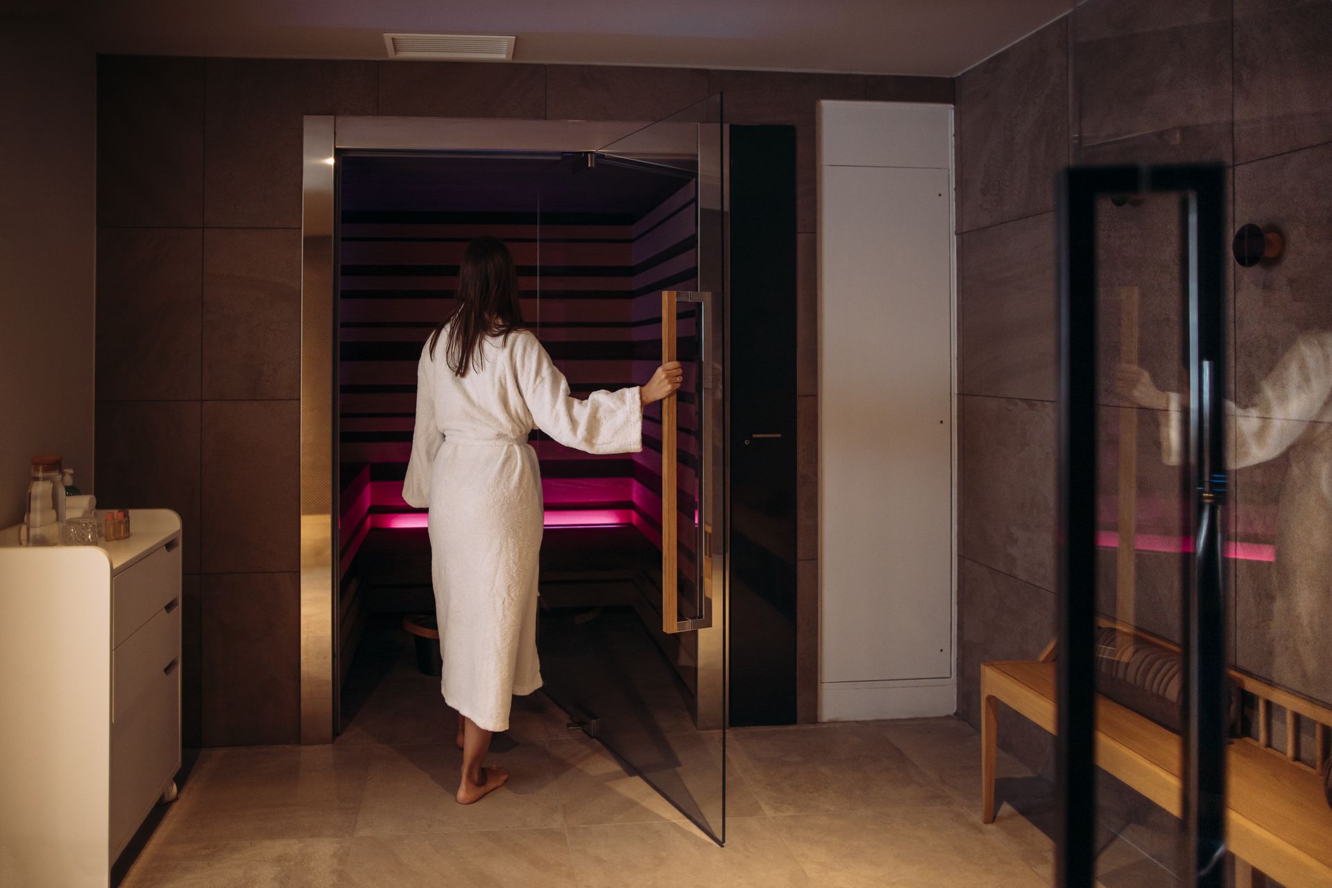Une femme en peignoir rentre dans le sauna du Spa Belaroïa