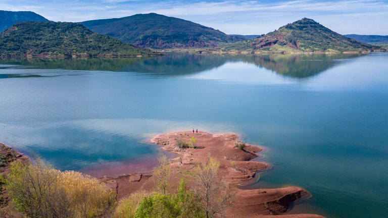 Rive des Vailhés au bord du lac du Salagou © Eric Brendle Deux randonneurs contemplent le lac du Salagou depuis la rive des Vailhés