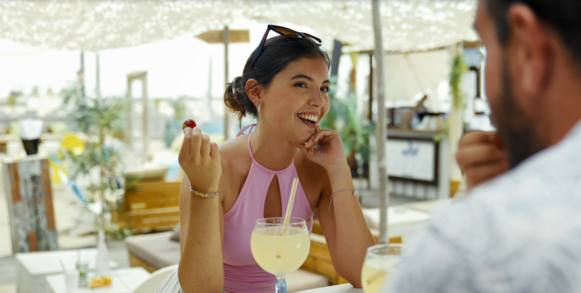 Jeune femme sirotant un cocktail en paillote au Cap d'Agde