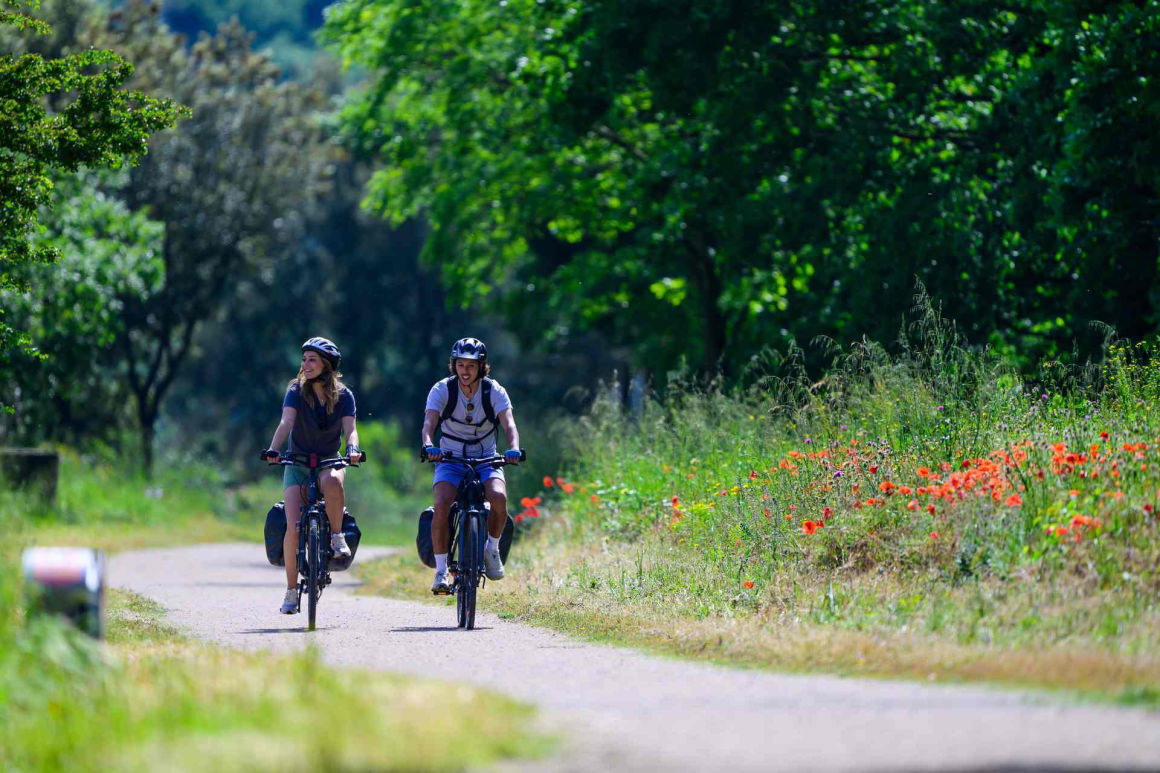 Couple en vélo itinérance sur la voie verte Passa Païs